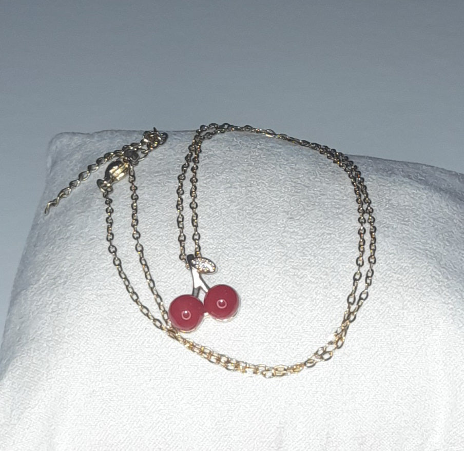 Titanium steel gold colour necklace with red cherries as pendant and zircon leaf
